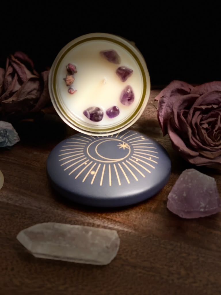 An open Hennys M. candle showing amethyst and dried rosebuds set into the soy wax